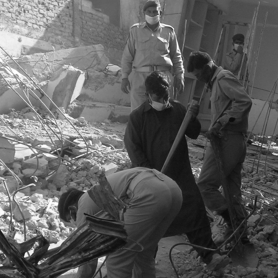 Pakistan Army men dig through rubble after 2005 earthquake