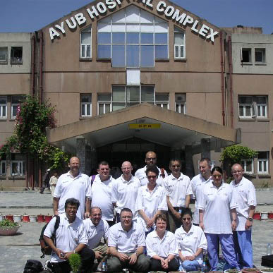 Mobile International Surgical Team members stand outside Ayub Hospital Complex in Abbottobad, Pakistan, 2005