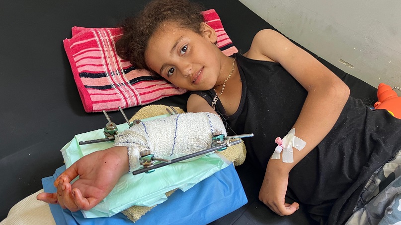 Young girl who was hit  in the arm by shrapnel after operation to shorten her arm and repair stabilised with external fixation