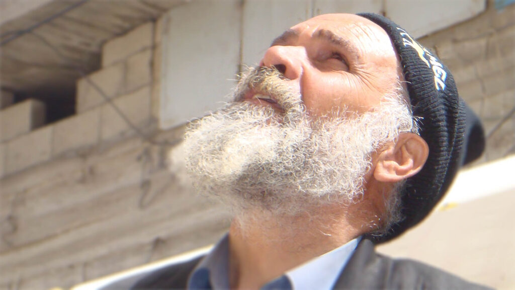 Man with beard looking up at sky 