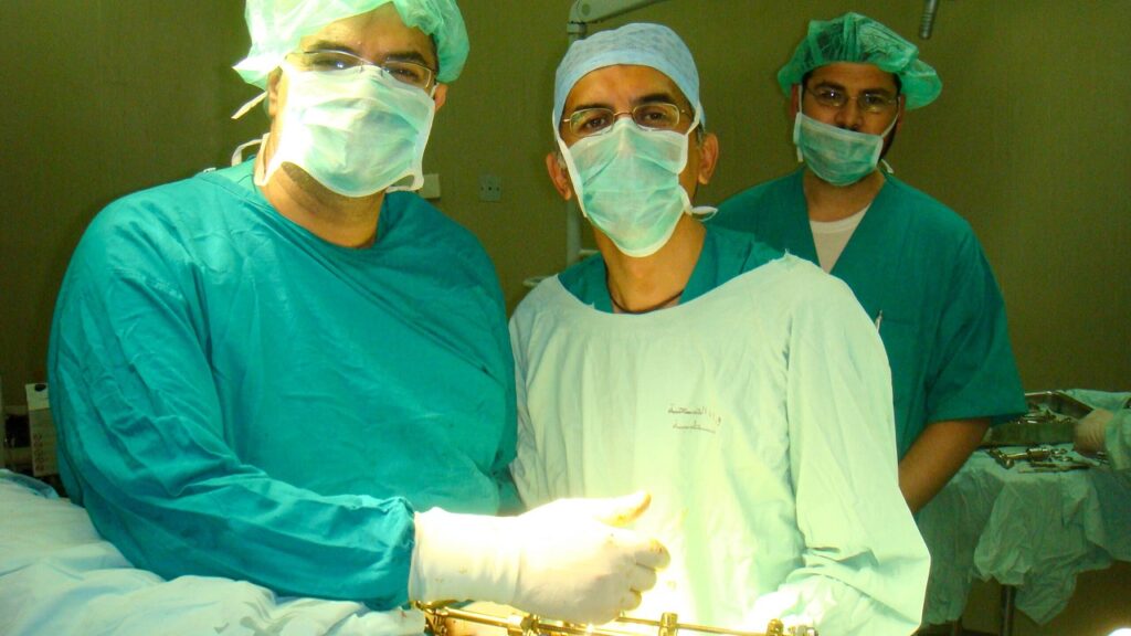 Two surgeons Ayman and Suheal standing over a patient with an Ilizarov frame in operating theatre at Nasser Hospital Gaza 2010